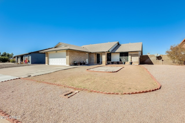 single story home with concrete driveway, brick siding, and an attached garage