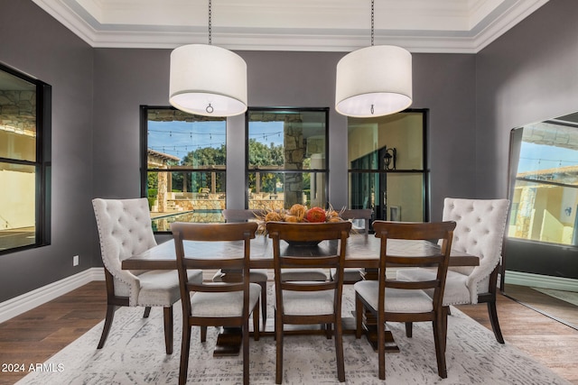 dining space featuring wood-type flooring and ornamental molding