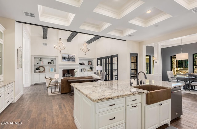 kitchen featuring pendant lighting, beam ceiling, sink, and dark wood-type flooring