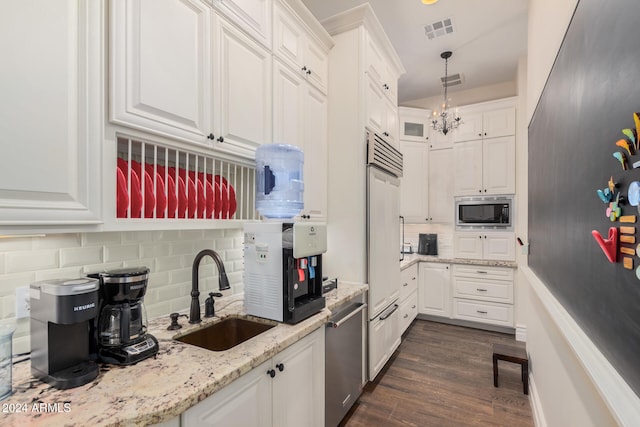 kitchen with backsplash, white cabinets, sink, built in appliances, and dark hardwood / wood-style flooring