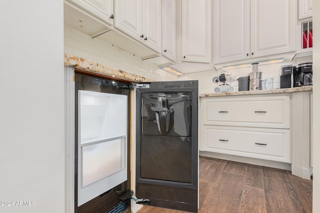 kitchen with white cabinets, backsplash, light stone countertops, and dark wood-type flooring