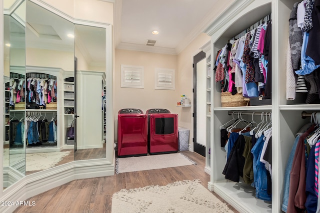 interior space with hardwood / wood-style flooring, ornamental molding, and washing machine and clothes dryer