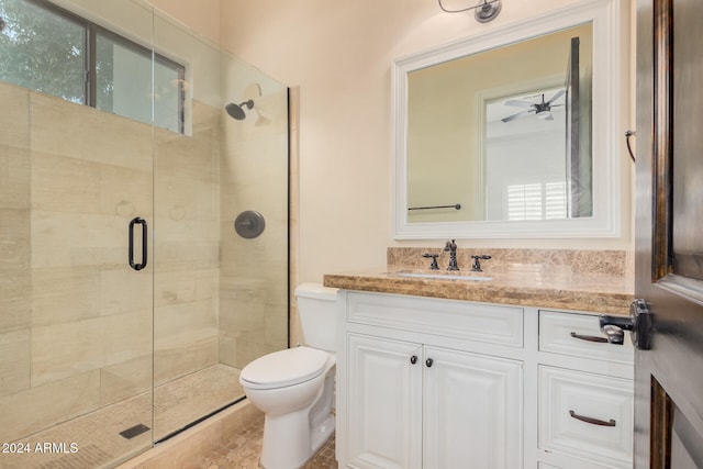 bathroom with ceiling fan, toilet, vanity, and walk in shower