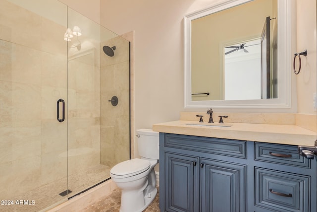 bathroom featuring ceiling fan, toilet, a shower with door, and vanity