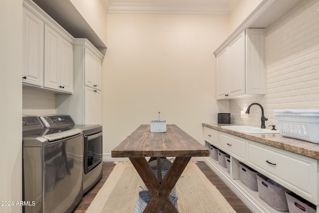 laundry room with cabinets, sink, dark hardwood / wood-style floors, washing machine and dryer, and ornamental molding