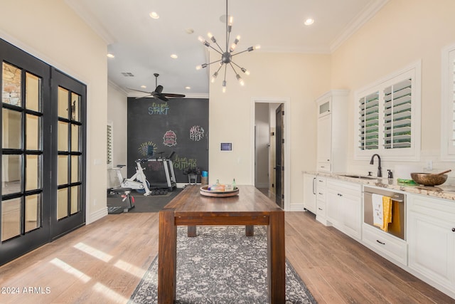 dining area featuring ceiling fan with notable chandelier, light hardwood / wood-style flooring, crown molding, and sink