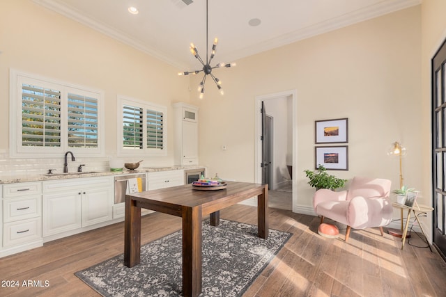 office featuring crown molding, light wood-type flooring, sink, and a chandelier