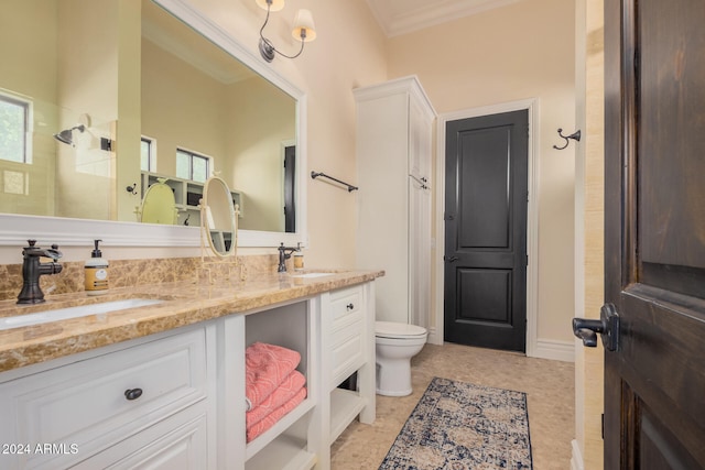 bathroom featuring toilet, plenty of natural light, vanity, and ornamental molding