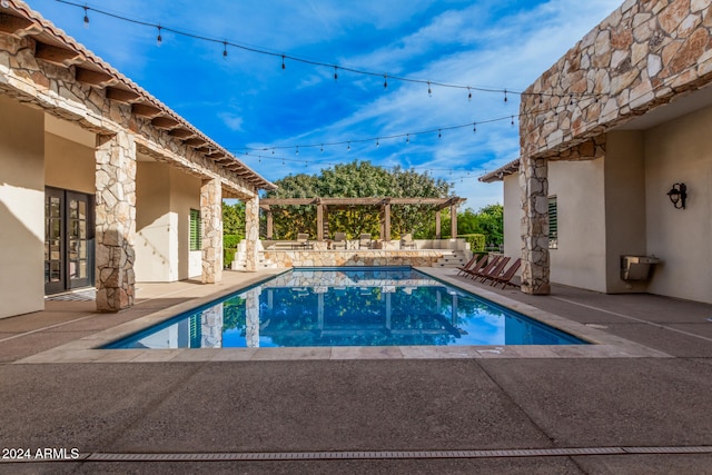 view of swimming pool with a jacuzzi, a pergola, and a patio area