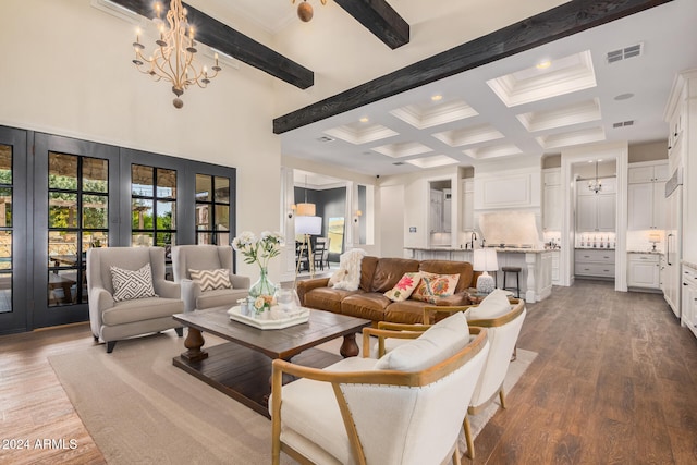 living room with beamed ceiling, an inviting chandelier, a high ceiling, and hardwood / wood-style flooring