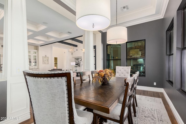 dining area featuring beam ceiling, hardwood / wood-style floors, coffered ceiling, and ornamental molding