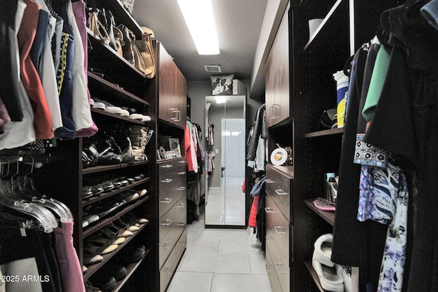 walk in closet with light tile patterned floors