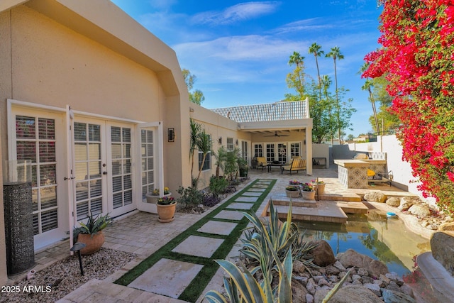 view of patio with a bar, ceiling fan, and french doors