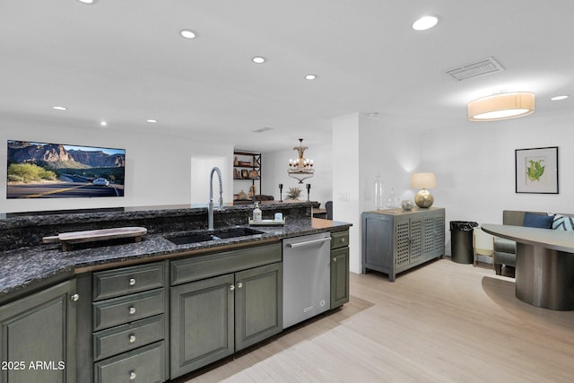 kitchen featuring dark stone countertops, dishwasher, pendant lighting, light hardwood / wood-style flooring, and sink