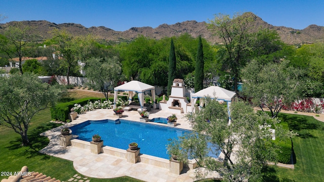 view of pool with a patio, a gazebo, a mountain view, and a yard