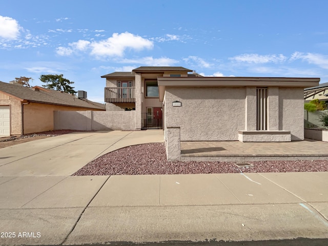 view of front of house featuring stucco siding and a balcony