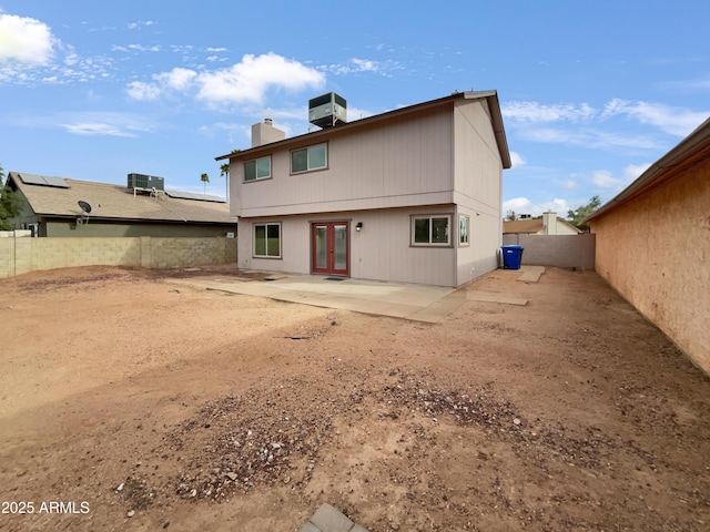 rear view of property featuring french doors, central AC unit, a fenced backyard, and a patio area