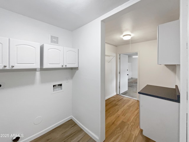 washroom featuring light wood finished floors, visible vents, baseboards, hookup for a washing machine, and cabinet space