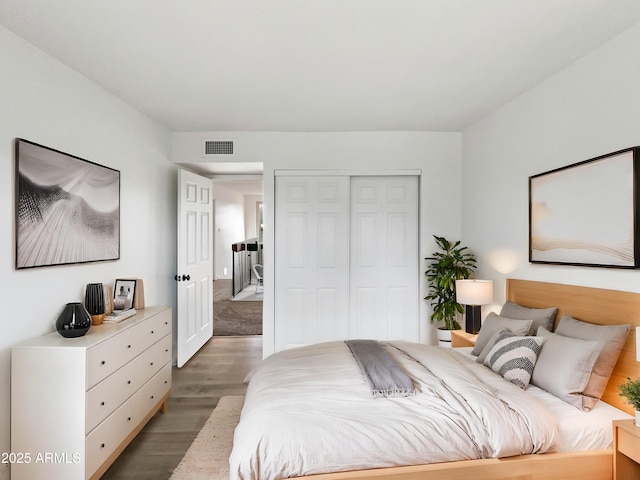 bedroom featuring visible vents, light wood-type flooring, and a closet