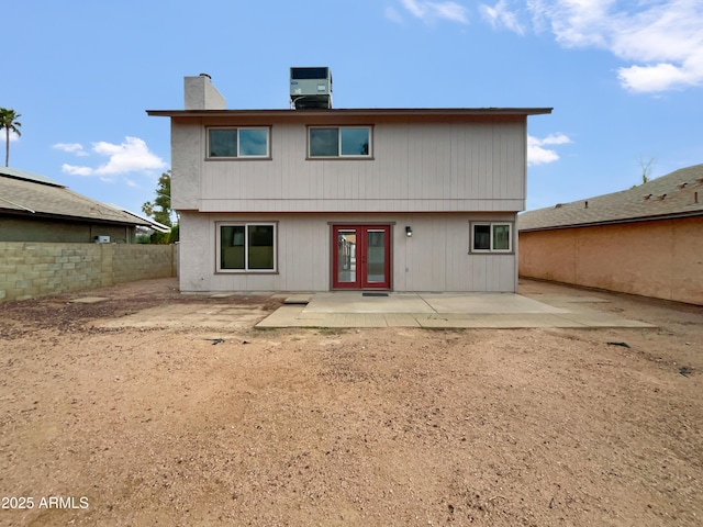 back of house featuring fence, central AC unit, french doors, a chimney, and a patio area