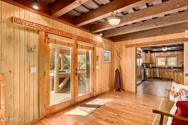 interior space featuring a wealth of natural light, beamed ceiling, and light wood-type flooring