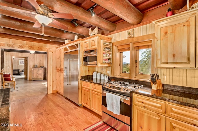 kitchen with beamed ceiling, appliances with stainless steel finishes, light hardwood / wood-style floors, dark stone counters, and wooden ceiling