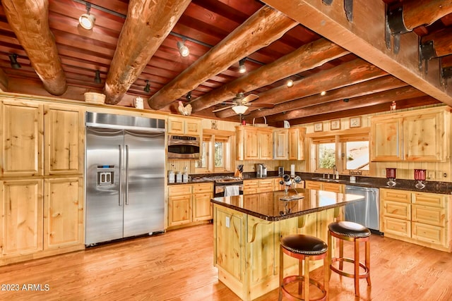 kitchen featuring appliances with stainless steel finishes, a kitchen island, light hardwood / wood-style floors, beam ceiling, and wooden ceiling