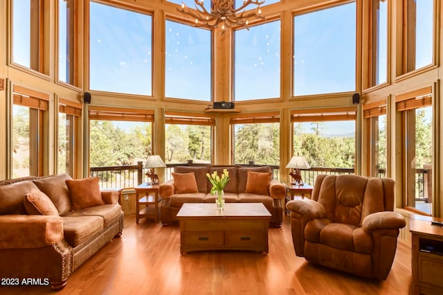 living room with hardwood / wood-style floors, a wealth of natural light, and a towering ceiling