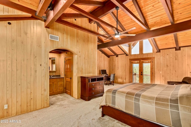 bedroom with wood walls, light carpet, beamed ceiling, french doors, and wood ceiling