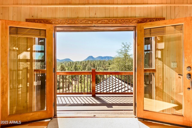 entryway with hardwood / wood-style floors, a mountain view, and wood walls