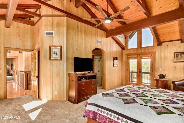 carpeted bedroom featuring wooden walls, beamed ceiling, and access to exterior