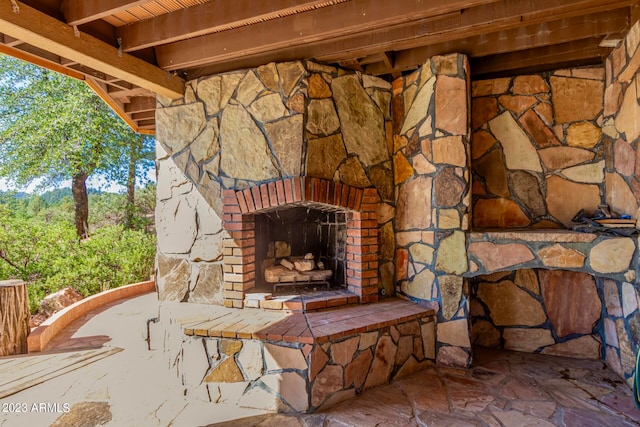 view of terrace with an outdoor stone fireplace