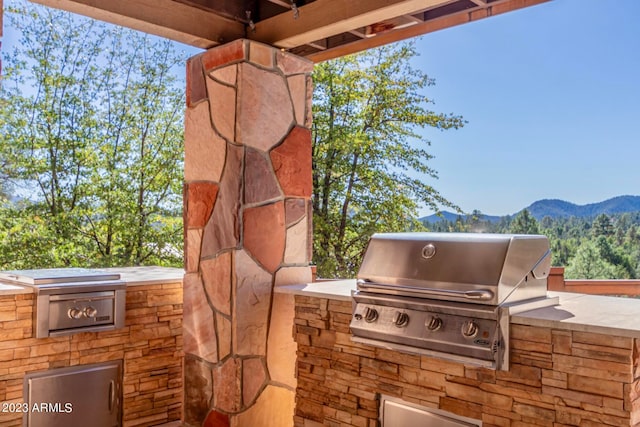 view of patio / terrace with a mountain view, area for grilling, and a grill