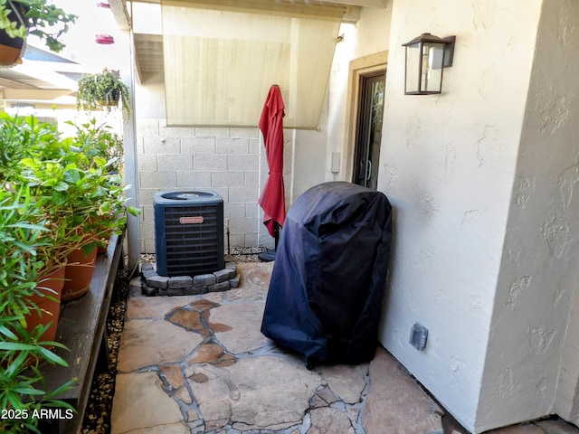 exterior details featuring central AC unit and stucco siding