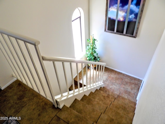 staircase with baseboards and tile patterned flooring