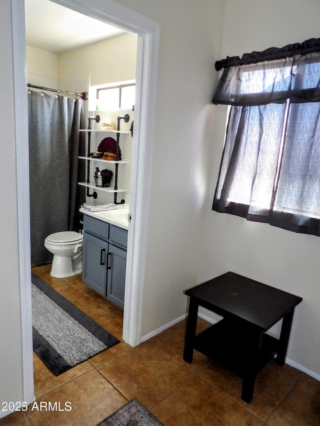 bathroom featuring tile patterned flooring, vanity, toilet, baseboards, and a shower with curtain