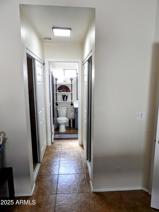 corridor featuring visible vents and baseboards