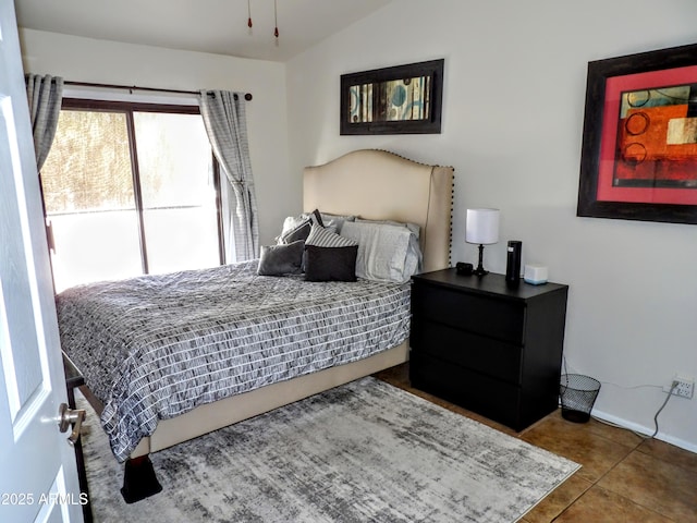 bedroom featuring tile patterned floors, vaulted ceiling, and baseboards