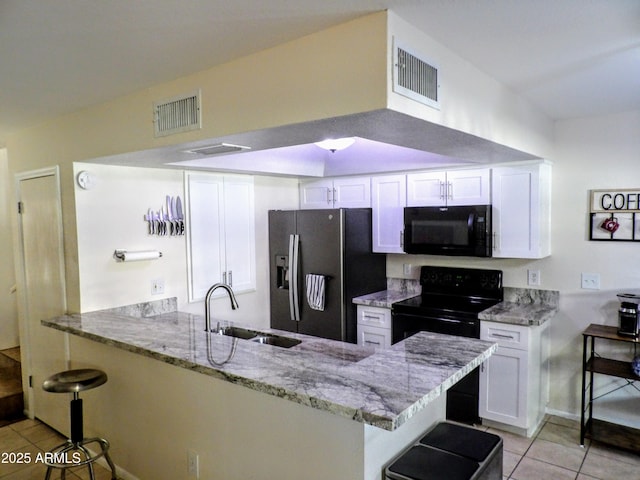 kitchen featuring visible vents, a sink, light tile patterned floors, and black appliances