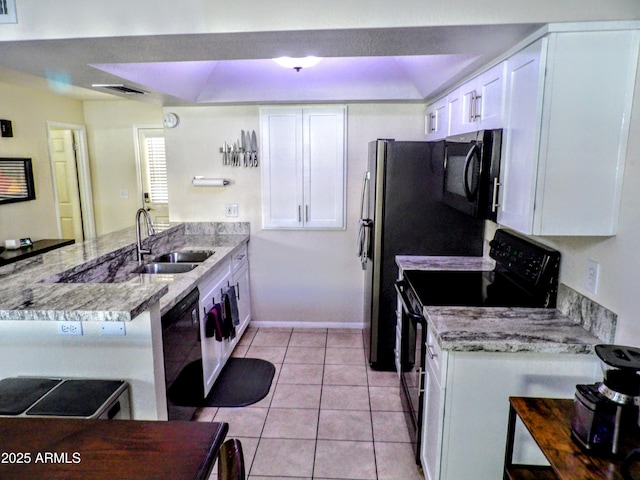 kitchen with a sink, black appliances, a peninsula, and white cabinetry