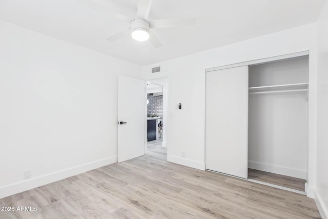 unfurnished bedroom featuring light hardwood / wood-style flooring, a closet, and ceiling fan