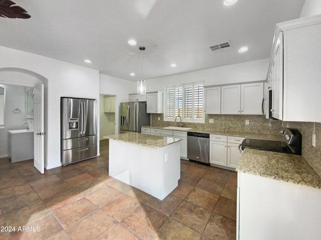 4319 E Vaughn Ave, Gilbert, AZ 85234 - kitchen with appliances with stainless steel finishes, backsplash, a kitchen island, recessed lighting, and white cabinetry