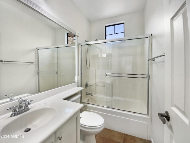 full bathroom with tile patterned flooring, vanity, toilet, and bath / shower combo with glass door