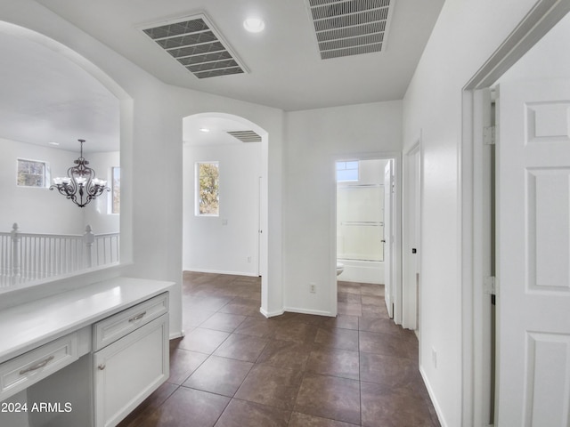 4319 E Vaughn Ave, Gilbert, AZ 85234 - hallway featuring arched walkways, dark tile patterned floors, a chandelier, and recessed lighting