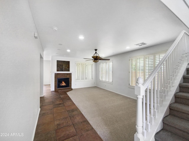 unfurnished living room featuring dark colored carpet and ceiling fan