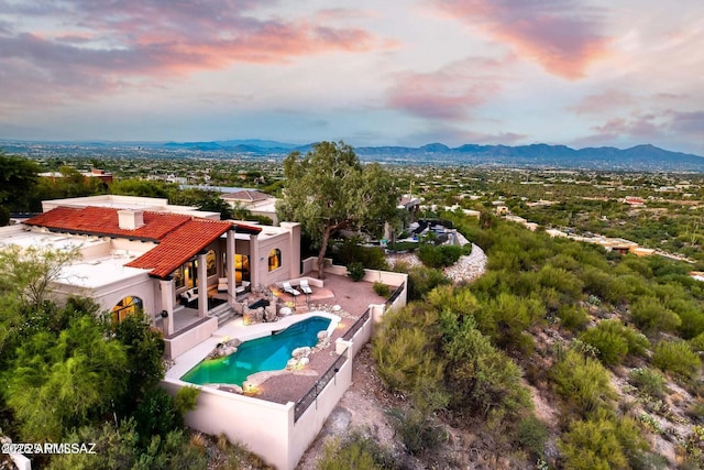 aerial view at dusk featuring a mountain view