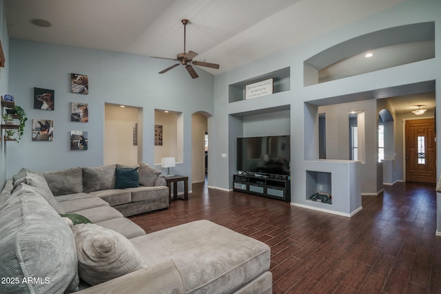 12503 W Vista Paseo Dr, Litchfield Park, AZ 85340 - living area with a ceiling fan, arched walkways, built in shelves, wood finished floors, and baseboards