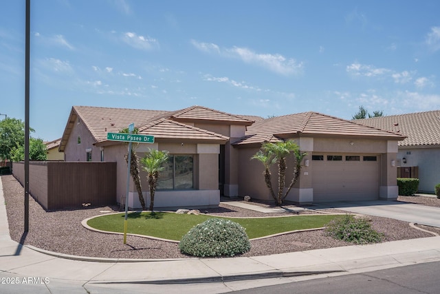 12503 W Vista Paseo Dr, Litchfield Park, AZ 85340 - ranch-style house with a tiled roof, driveway, fence, an attached garage, and stucco siding