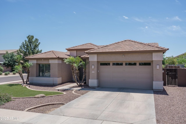 12503 W Vista Paseo Dr, Litchfield Park, AZ 85340 - prairie-style house with a tiled roof, driveway, fence, an attached garage, and stucco siding