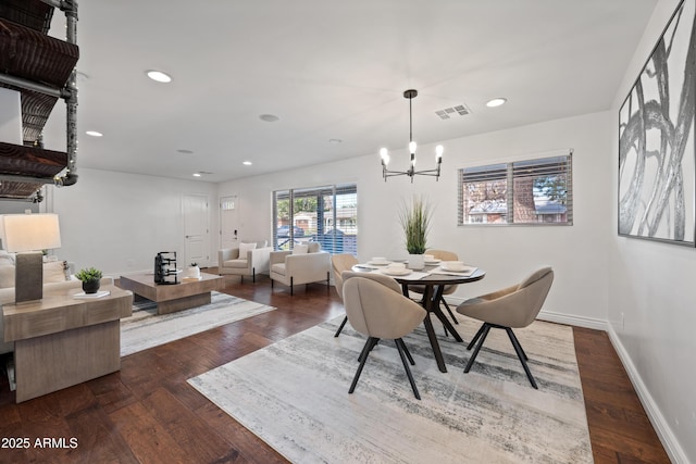 dining space with dark hardwood / wood-style floors and a notable chandelier